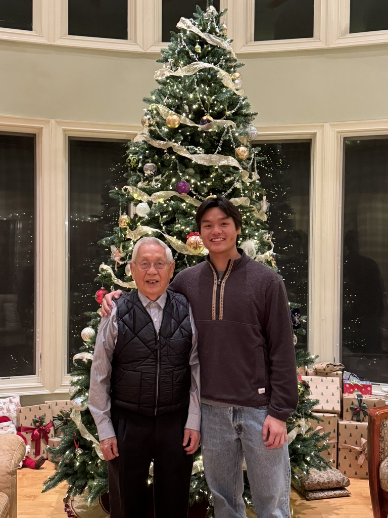 Jeremy with family in front of a Christmas tree